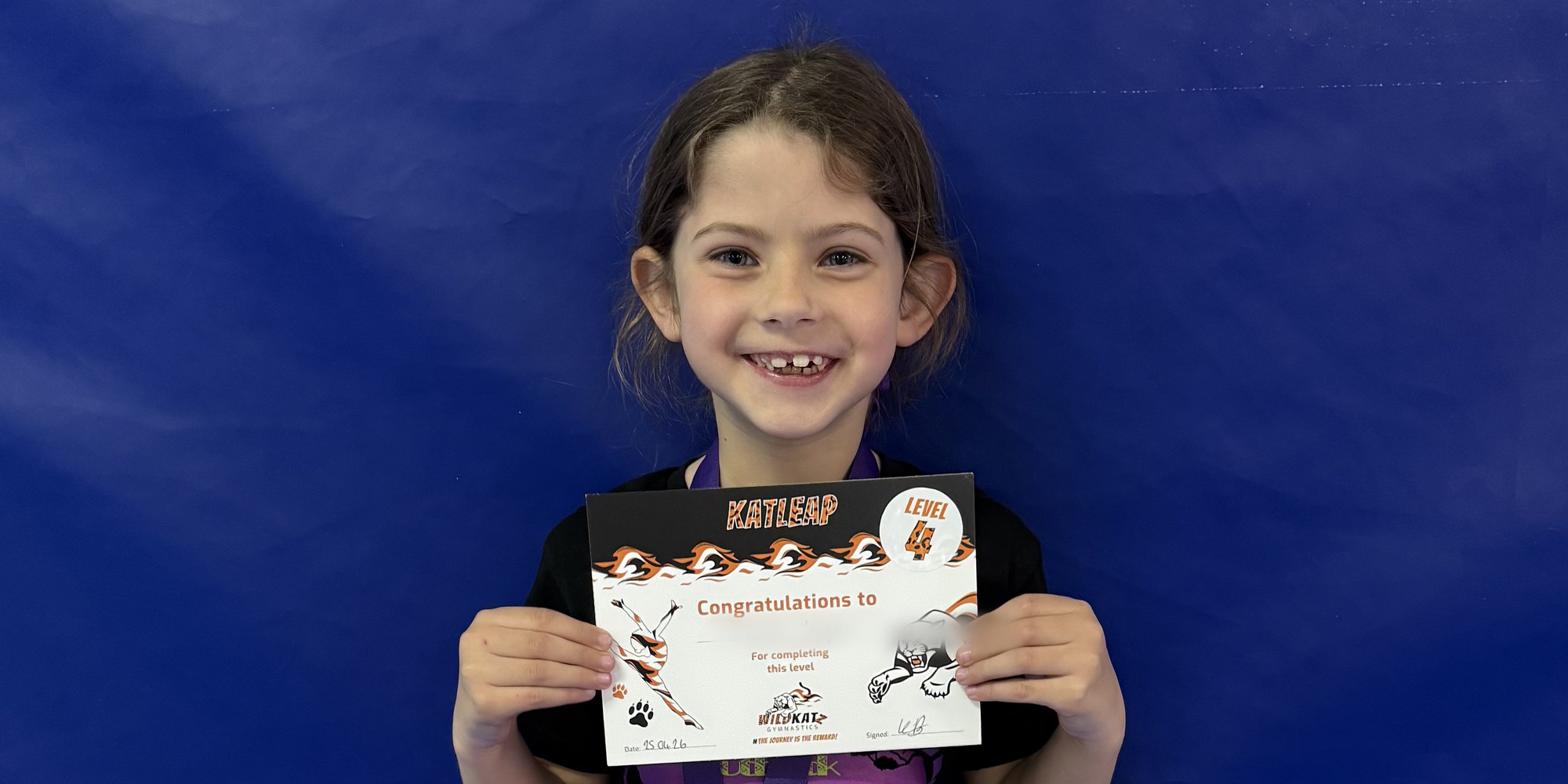 A gymnast with her Katleap award certificate