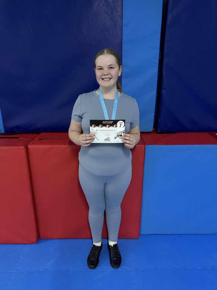 A gymnast with her Katleap award certificate