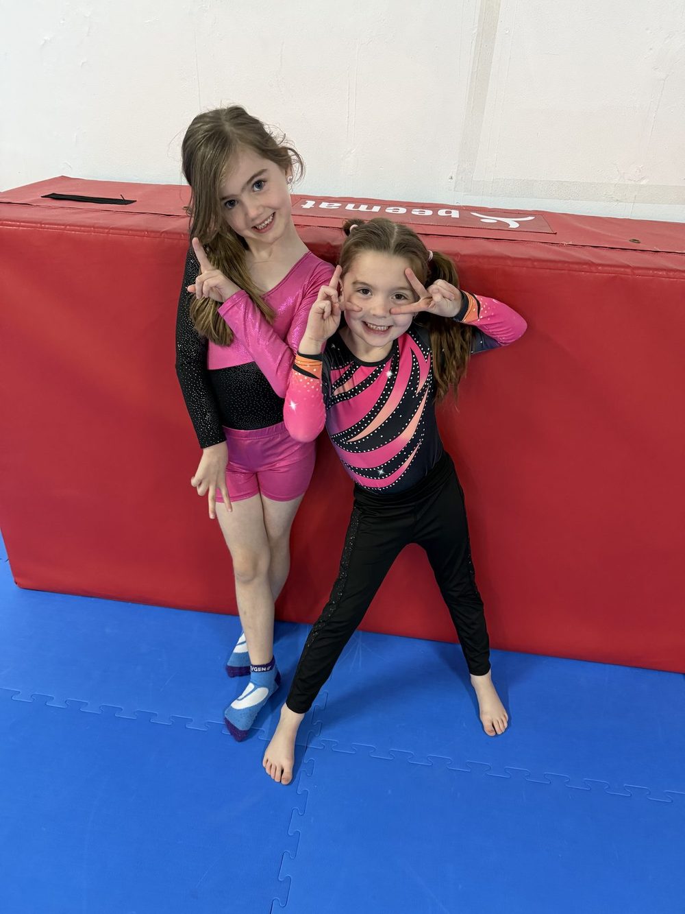 Two gymnasts smiling in the gym
